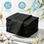 Stack of 100 black disposable massage table sheets, folded neatly, with one sheet partially unfolded on a table.