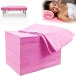 Stack of 100 pink disposable waterproof massage table sheets, unfolded to show texture.