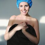 A stack of individually wrapped black disposable spa wraps, showing the non-woven fabric texture and adjustable design.