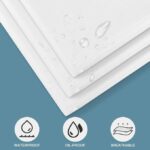 Stack of 100 white OUMETE disposable massage table sheets, unfolded to show their rectangular shape and texture.