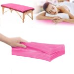 Stack of 20 pink disposable non-woven fabric massage table sheets, folded neatly.