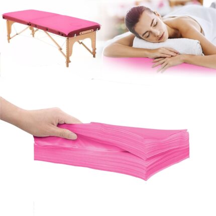 Stack of 20 pink disposable non-woven fabric massage table sheets, folded neatly.