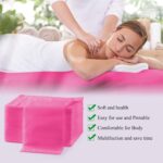 Stack of 20 pink disposable non-woven fabric massage table sheets, folded neatly.