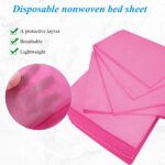 Stack of 20 pink disposable non-woven fabric massage table sheets, folded neatly.
