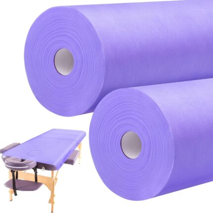 Two rolls of purple Tudomro disposable non-woven massage table sheets, unrolled slightly to show texture.