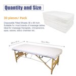 Stack of 30 white disposable fitted massage table sheets with elastic edges, on a spa table.