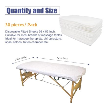 Stack of 30 white disposable fitted massage table sheets with elastic edges, on a spa table.