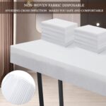 Stack of 100 white disposable non-woven bed sheets for massage tables and spa beds, neatly folded.