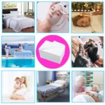 Stack of 100 white disposable non-woven bed sheets for massage tables and spa beds, neatly folded.