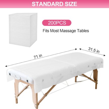 Stack of white disposable non-woven fabric massage table sheets, unfolded on a treatment bed.