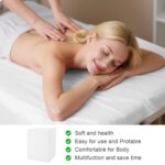 Stack of white disposable non-woven fabric massage table sheets, unfolded on a treatment bed.